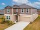 Two-story house with brown siding, beige garage door, and landscaping at 11307 Linden Depot Rd, San Antonio, FL 33576