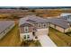 Two-story house with brown siding, beige garage door, and landscaping at 11307 Linden Depot Rd, San Antonio, FL 33576