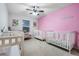 Charming ' bedroom with two cribs and pink walls at 11514 Brighton Knoll Loop, Riverview, FL 33579