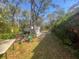 Backyard with shed, lawn equipment, and overgrown vegetation at 12411 Eagle Lake Ave, New Port Richey, FL 34654