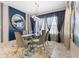Elegant dining room with glass table and blue velvet chairs at 12854 Boggy Creek Dr, Riverview, FL 33579