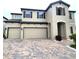 Tan two-story house with a three-car garage and landscaping at 12854 Boggy Creek Dr, Riverview, FL 33579