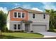 Two-story house with orange accents and a two-car garage at 14729 Summer Branch Dr, Lithia, FL 33547