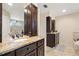 Double vanity bathroom with granite countertops and dark wood cabinets at 18321 Citation St, Lutz, FL 33549