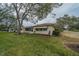 House exterior showcasing a side yard and screened porch at 2035 Hampstead Cir # 275, Sun City Center, FL 33573