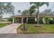 Single story home with carport, landscaped yard, and palm trees at 2035 Hampstead Cir # 275, Sun City Center, FL 33573