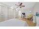 Bright bedroom with hardwood floors, ceiling fan, and built-in workspace at 2781 Westchester Dr S, Clearwater, FL 33761