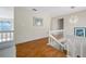 Bright upper hallway with hardwood floors, chandelier, and view of lower level at 2781 Westchester Dr S, Clearwater, FL 33761