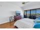 Main bedroom with water views, hardwood floors, and a large sliding glass door leading to a balcony at 2795 Kipps Colony S Dr # 305, St Petersburg, FL 33707