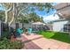 Landscaped backyard with a patio, fire pit, and lush green grass at 3116 Winchester Dr, Dunedin, FL 34698