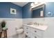 Bathroom with white vanity and a blue wall at 3116 Winchester Dr, Dunedin, FL 34698