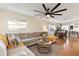 Open concept living area with L-shaped sofa and ceiling fan at 3116 Winchester Dr, Dunedin, FL 34698