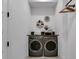 A modern laundry area featuring sleek washer and dryer, paired with unique decor and diamond pattern flooring at 4816 W Sunset Blvd, Tampa, FL 33629