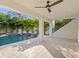 Outdoor living space boasts a covered patio, ceiling fan, and a swimming pool with lush landscaping at 4816 W Sunset Blvd, Tampa, FL 33629