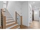 Bright staircase with wood steps and a modern metal railing leading to the upper level at 4816 W Sunset Blvd, Tampa, FL 33629