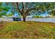 Large backyard with a sprawling tree and a screened patio at 5718 Magnolia N St, St Petersburg, FL 33703