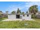 Large backyard with concrete patio and unkempt grass at 6702 Sandra Dr, Port Richey, FL 34668