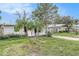 Side view of a light brick ranch home with palm trees and a partially visible neighbor's house at 6702 Sandra Dr, Port Richey, FL 34668
