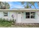 Front entrance of a ranch home featuring a white door and light brick exterior at 6702 Sandra Dr, Port Richey, FL 34668