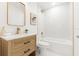 Modern bathroom with white tile, a soaking tub, and a light wood vanity at 674 Frederica Ln, Dunedin, FL 34698