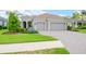 Two-story house with three-car garage, manicured lawn, and tile driveway at 1069 River Wind Cir, Bradenton, FL 34212