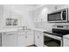 White kitchen features stainless steel appliances and a chandelier at 15890 Sanctuary Dr, Tampa, FL 33647
