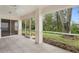 Spacious screened porch with tile flooring, overlooking a lush, tree-filled backyard at 15890 Sanctuary Dr, Tampa, FL 33647
