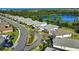 An aerial view showcases upscale homes along a street next to a scenic lake and verdant trees at 19891 Bridgetown Loop, Venice, FL 34293