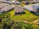 Aerial view of a backyard with a green lawn, covered patio, and surrounding landscaping at 19891 Bridgetown Loop, Venice, FL 34293