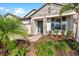 Inviting front entrance featuring stone detail and lush tropical landscaping at 19891 Bridgetown Loop, Venice, FL 34293