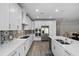 The kitchen features stainless steel appliances, custom cabinets, and wood flooring at 19891 Bridgetown Loop, Venice, FL 34293