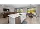 Kitchen island with a stainless steel dishwasher, a double basin sink and bar stool seating at 19891 Bridgetown Loop, Venice, FL 34293
