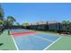 Outdoor pickleball court featuring red and blue playing surfaces, set against a backdrop of lush landscaping at 19891 Bridgetown Loop, Venice, FL 34293