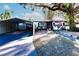 Updated home exterior with landscaped yard, carport and walkway at 2005 E Crenshaw St, Tampa, FL 33610
