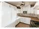 White kitchen with stainless steel appliances and wood-look floors at 2005 E Crenshaw St, Tampa, FL 33610