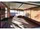 Enclosed sunroom, features a metal table and shelving unit at 2005 E Crenshaw St, Tampa, FL 33610