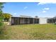 Home exterior showcasing a large backyard and screened patio at 3403 Overland Dr, Holiday, FL 34691