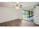 Bedroom with sliding glass doors to the backyard and wood-look floors at 3403 Overland Dr, Holiday, FL 34691