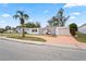 Updated single story home with a large driveway and a palm tree in the front yard at 3403 Overland Dr, Holiday, FL 34691