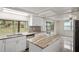 Modern kitchen with white cabinets, granite countertops, and stainless steel appliances at 3403 Overland Dr, Holiday, FL 34691