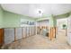 Bedroom under renovation with damaged walls and flooring, view to another room at 3939 Venetian Way, Tampa, FL 33634