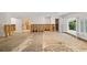 A living room under renovation, showing exposed walls, damaged flooring and access to other rooms at 3939 Venetian Way, Tampa, FL 33634