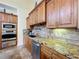 Modern kitchen with granite countertops, wood cabinets, and stainless steel appliances at 4178 Des Prez Ct, Hernando Beach, FL 34607
