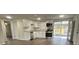 Modern kitchen featuring white cabinets, stainless steel appliances, and wood-look floors at 7318 Dianne Dr, New Port Richey, FL 34652