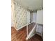 Upper hallway with floral wallpaper and wood flooring at 7634 Desoto Ct, Tampa, FL 33615