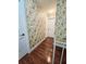 Hallway with floral wallpaper and wood flooring at 7634 Desoto Ct, Tampa, FL 33615