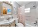 Bathroom with shower/tub combo, updated vanity, and decorative mirror at 8 Citrus Dr, Palm Harbor, FL 34684