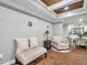 Sitting area featuring a bench and armchair, hardwood floors and wood-beam ceiling at 8 Citrus Dr, Palm Harbor, FL 34684