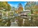 Serene waterfront view with house reflection and dock at 8 Citrus Dr, Palm Harbor, FL 34684
