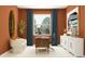 Bright home office with orange walls and a large desk at 9650 Minnow Ray Dr, Land O Lakes, FL 34638